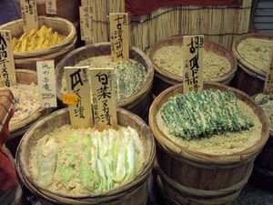 상점에서 쌀겨에 묻혀 판매되는 누카즈케. 둥근 나무 통 안에 담긴 쌀겨 위로 쌀겨가 묻은 야채가 쌓여 있다.